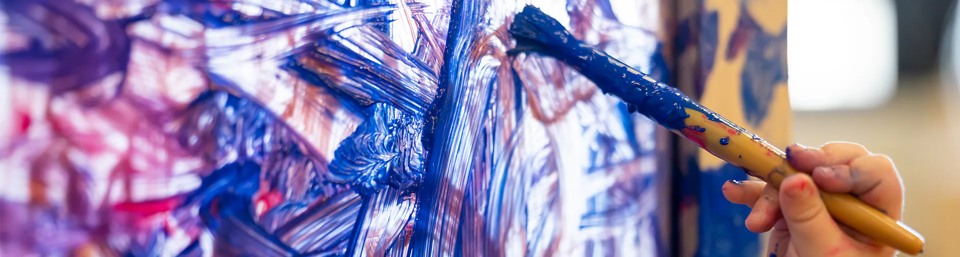 Child painting blue canvas